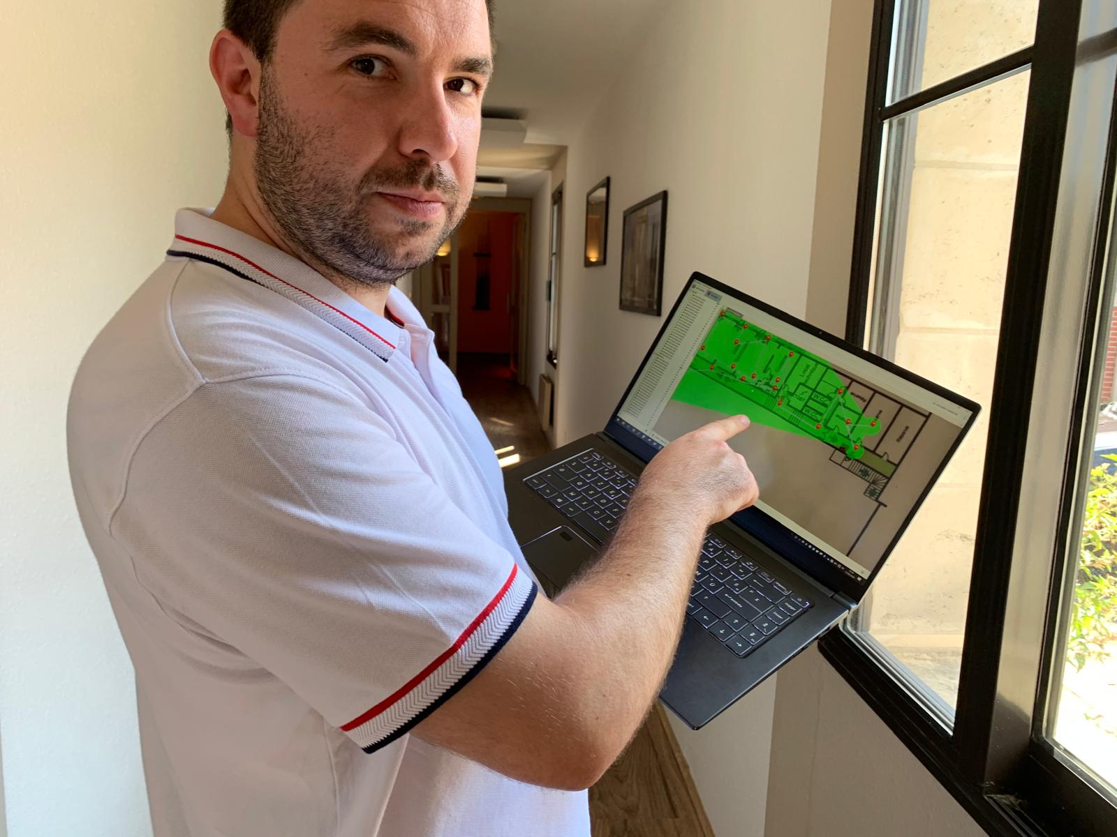 Technicien CN-Tech analysant un schéma réseau sur un ordinateur portable